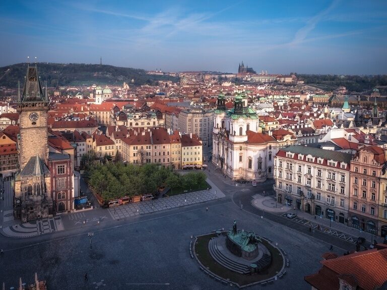 Panoramaaufnahme vom Altstädter Ring in Prag mit Rathaus, Jan-Hus-Denkmal, Kirchen und der Prager Burg im Hintergrund.