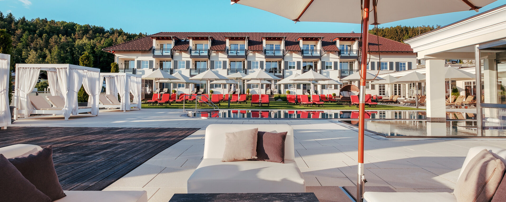 Der Wellnessgarten mit Sonnenliegen, balinesischen Betten und Terrasse mit Lounge-Möbeln für entspannte Sonnenstunden im Hotel Oswald.