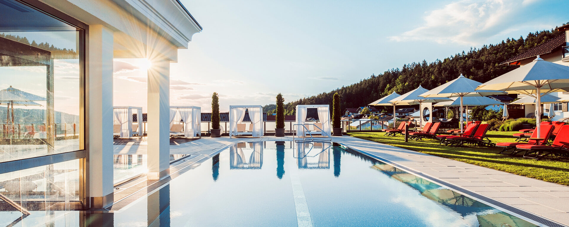 Der beheizte Außenpool im Hotel Oswald bietet luxuriöses Badevergnügen mit Sonnenliegen, Daybeds und Ausblick in den Bayerischen Wald.