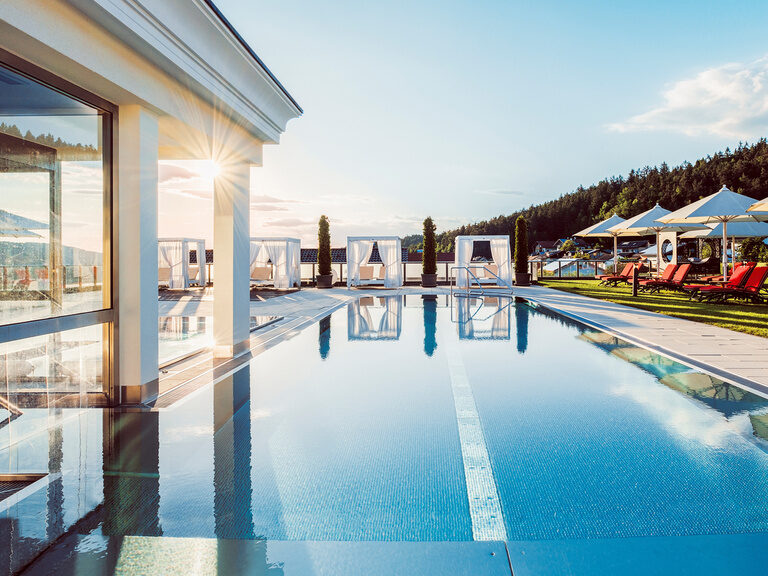 Der beheizte Außenpool im Hotel Oswald bietet luxuriöses Badevergnügen mit Sonnenliegen, Daybeds und Ausblick in den Bayerischen Wald.
