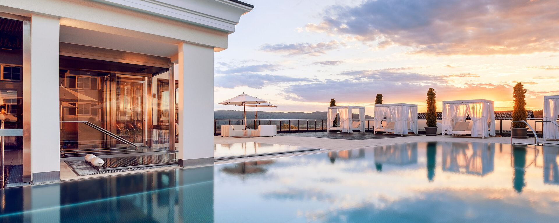 Das Dachschwimmbad im Wellnesshotel Oswald, perfekt für eine entspannende Schwimmrunde bei Sonnenuntergang im Bayerischer Wald.
