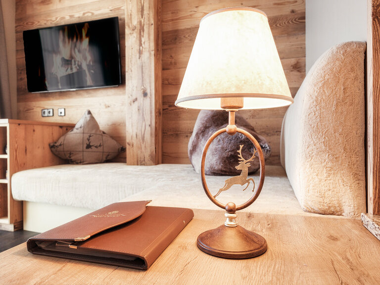 Das Doppelzimmer Hirschenstein mit Tisch und moderner Lampe neben dem Couch im Hotel Oswald.