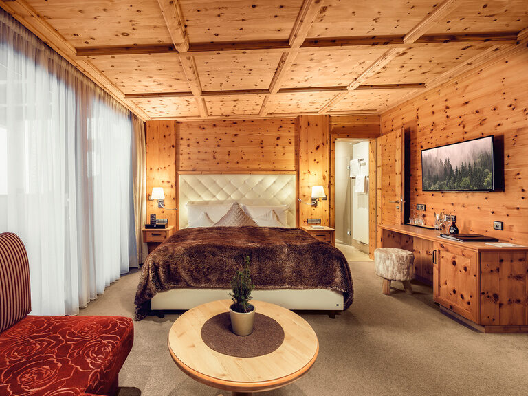 Das Doppelzimmer Morgentau im Hotel Oswald besticht durch seine natürliche Zirbenholzausstattung, ein komfortables Boxspringbett mit weicher Felldecke