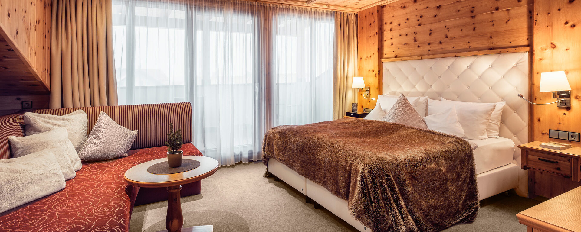 Doppelzimmer Morgentau im Hotel Oswald im Bayerischen Wald mit gemütlichem Holzmobiliar und elegantem Bett.