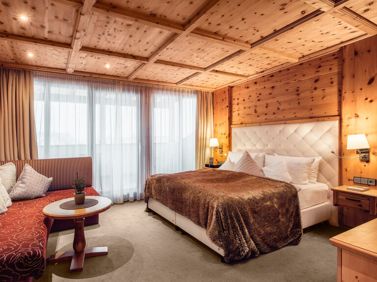 Doppelzimmer Morgentau im Hotel Oswald im Bayerischen Wald mit gemütlichem Holzmobiliar und elegantem Bett.