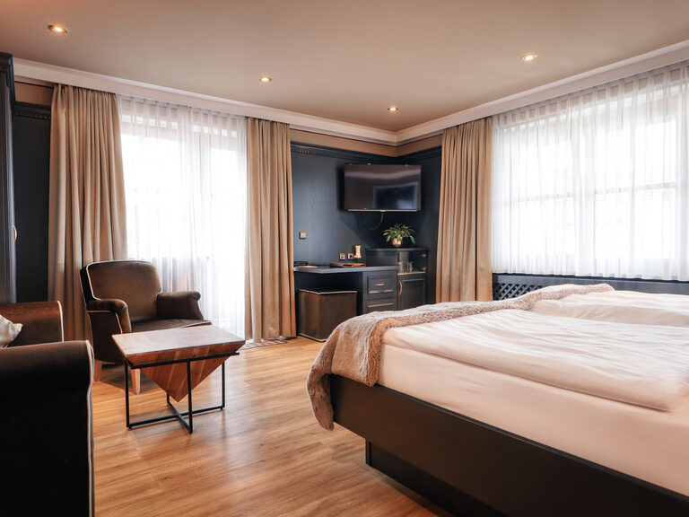 Das gemütliche Schlafzimmer mit passendem Sofa im Doppelzimmer Plus 117 im Hotel Oswald Bayerische Wald.