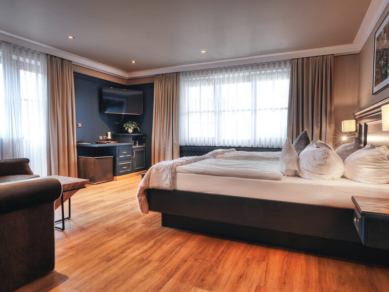 Das gemütliche Schlafzimmer mit passendem Sofa im Doppelzimmer Plus 117 im Hotel Oswald.