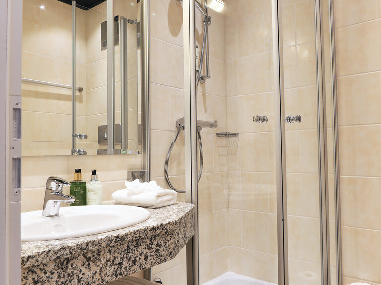 Das Badezimmer im Einzelzimmer des Hotel Oswald mit moderner Dusche und hochwertigen Pflegeprodukten.