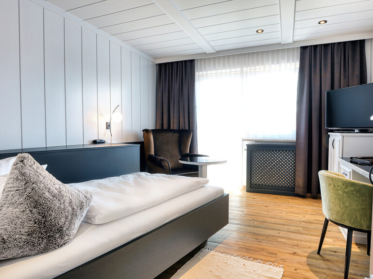 Das stilvoll eingerichtete Einzelzimmer im Landromantik Hotel Oswald im Bayerischen Wald mit Bett und Schreibtisch.