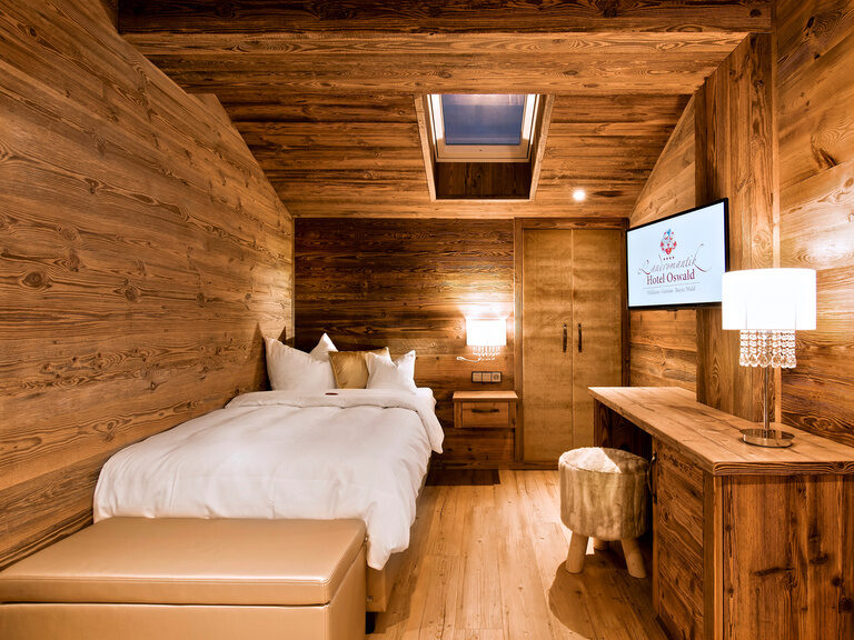 Das stilvolle Einzelzimmer der Top Suite Storchennest Plus im Hotel Oswald – rustikales Design trifft modernen Komfort.