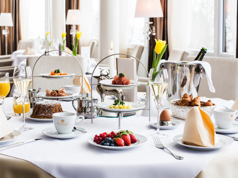Der  Festlich gedeckter Frühstückstisch mit Etageren, Obst und Sekt im Hotel Oswald.