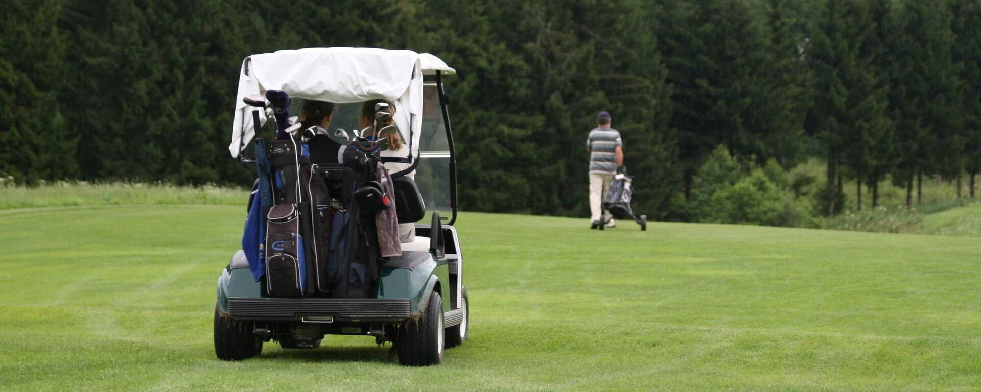 Ein Golfer fährt im Golfwagen über das Gras im Golfclub Bayerischer Wald.