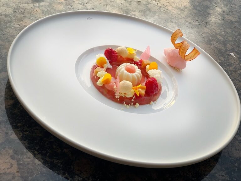 Feines Dessert mit Früchten und Creme auf weißem Teller im Hotel Oswald.