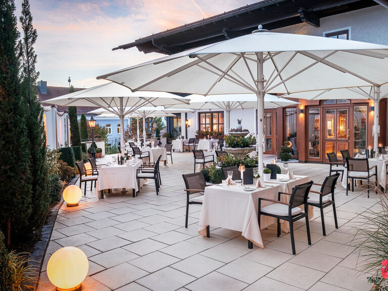 Abendstimmung auf der Terrasse des Hotel Oswald mit gedeckten Tischen.