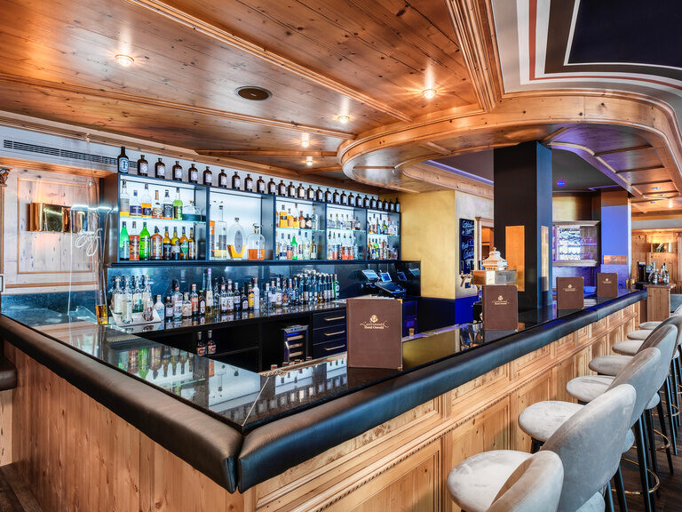 Die elegante Hotelbar im Hotel Oswald vereint modernes Design mit alpinem Charme und bietet eine große Auswahl an hochwertigen Spirituosen.