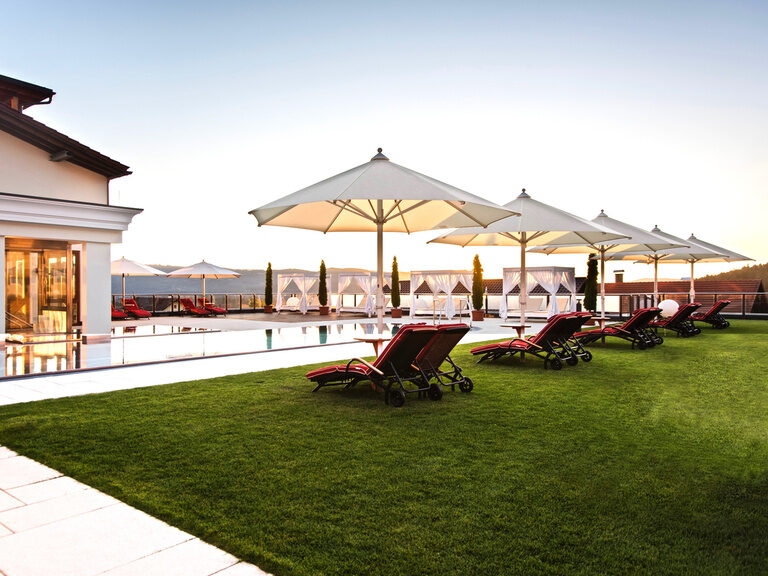 Gemütlicher Hotelgarten mit Liegemöglichkeit und Sonnenschirmen im Hotel Oswald.