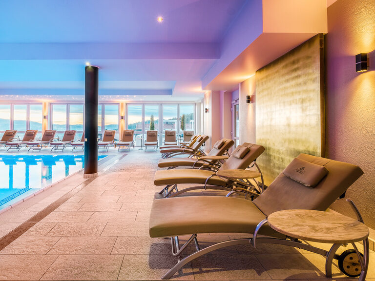 Der moderne Inndoorpool mit bequemen Liegestühlen im luxuriösen Wellnesshotel Oswald Bayerischer Wald.