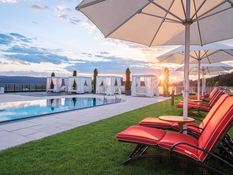 Der stilvolle Infinitypool im Wellnesshotel Oswald begeistert mit Sonnenuntergangspanorama, Daybeds und exklusivem Ambiente im Bayerischen Wald.
