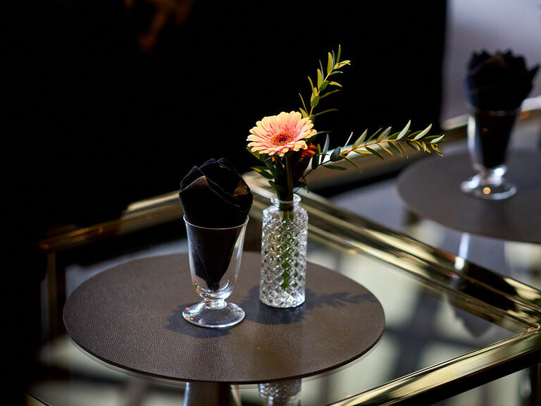 Stilvolle Lounge im Hotel Oswald mit edlen Glastischen, dezenter Blumendekoration und gemütlichen Sitzmöbeln für entspannte Genussmomente.