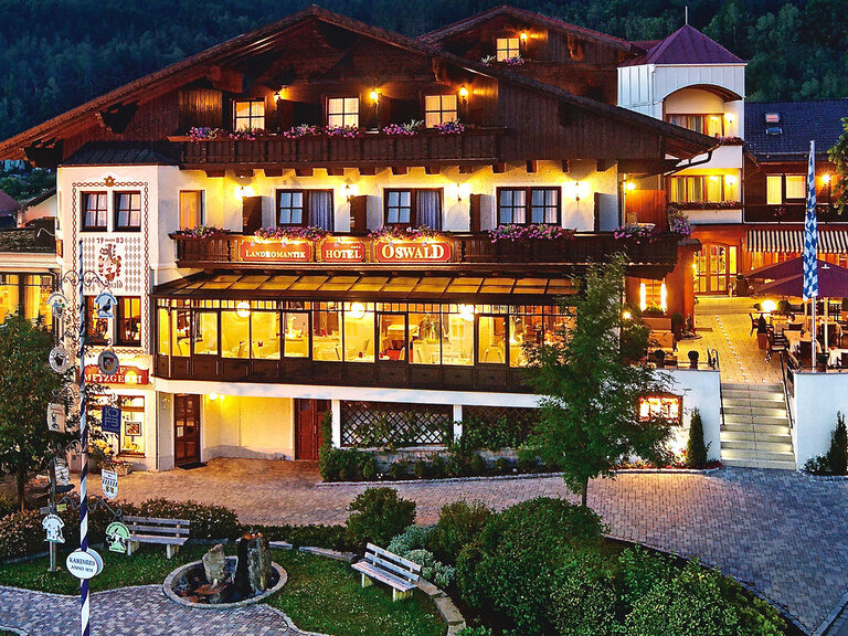 Hotel Oswald Bayerischer Wald bei Abenddämmerung mit beleuchteter Fassade.