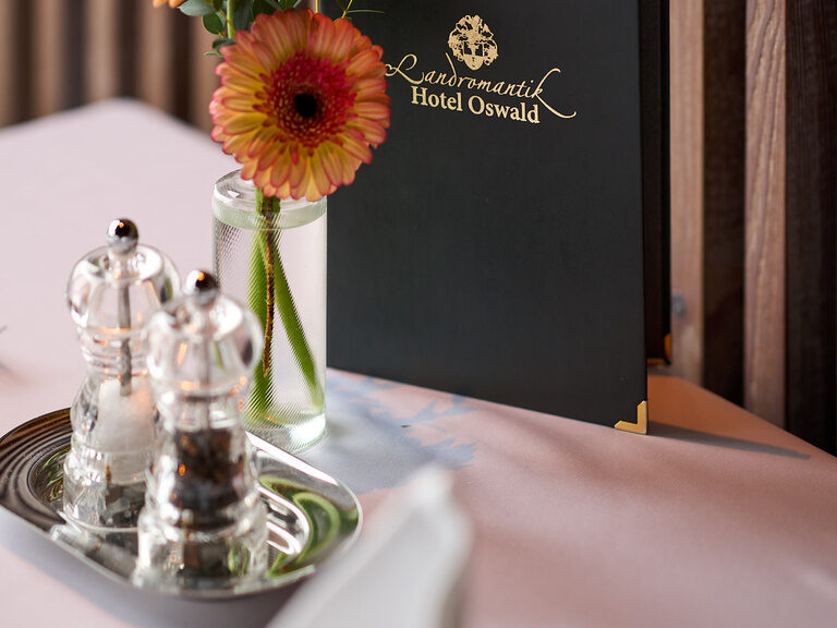 Stilvoll gedeckter Tisch mit eleganter Speisekarte im Landromantik Hotel Oswald.