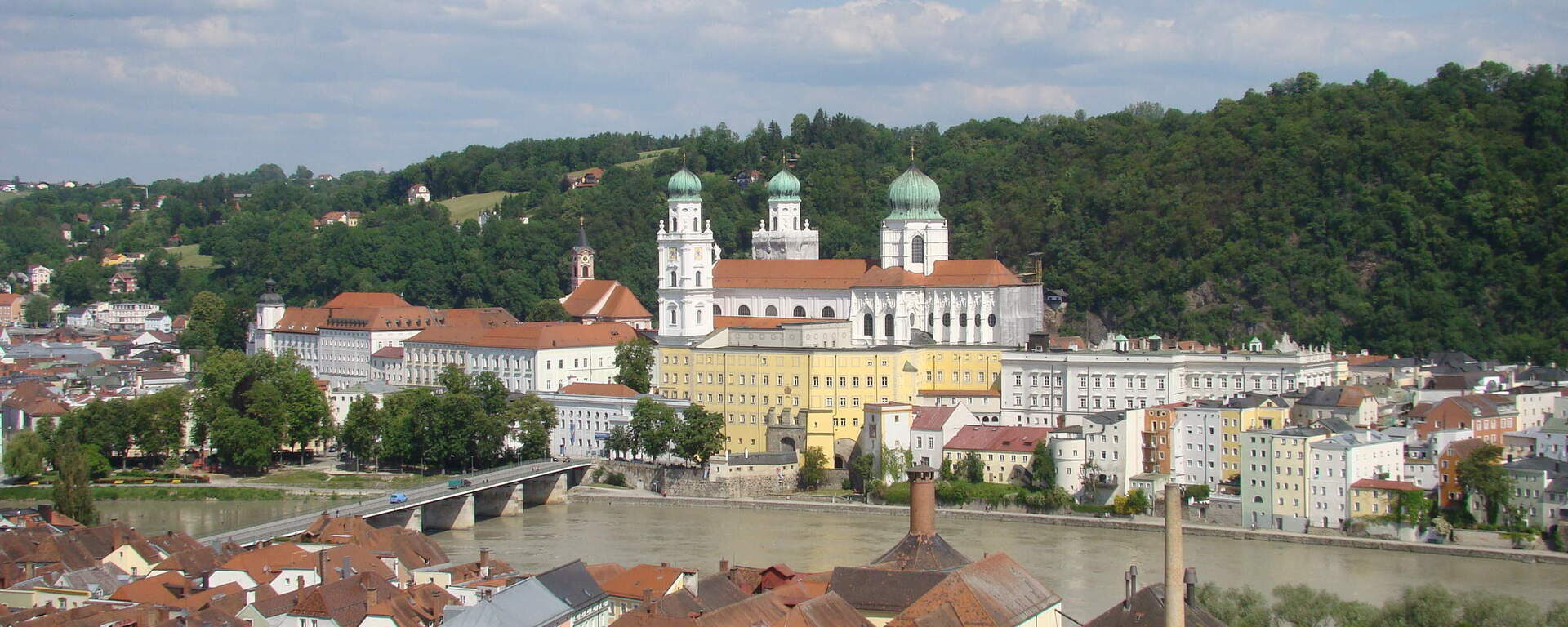 Blick auf die Altstadt von Passau mit dem Stephansdom und der Donau im Vordergrund.