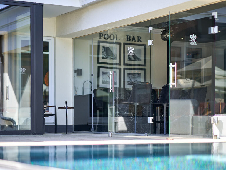 Poolbar im Hotel Oswald mit stilvollem Design, gemütlichen Sitzbereichen und direktem Blick auf den erfrischenden Außenpool.