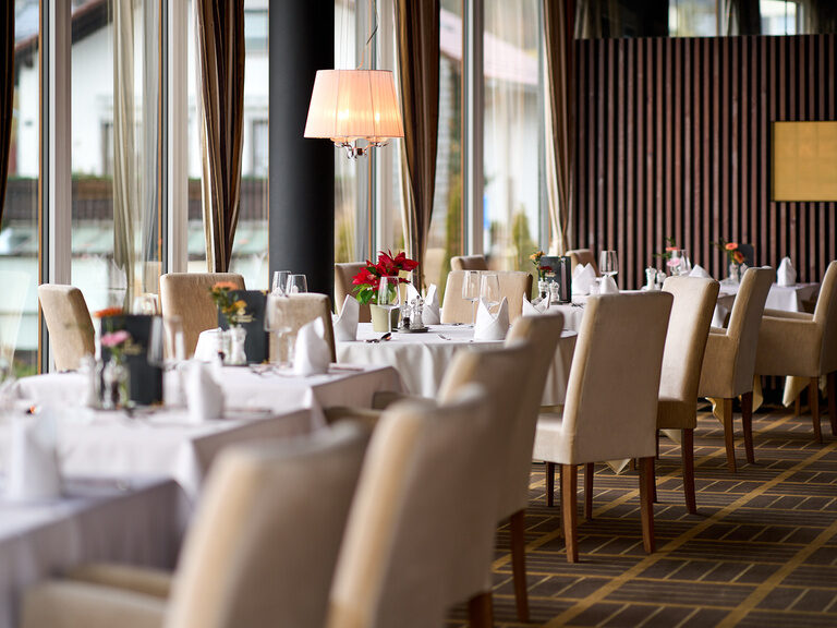Das Restaurant im Hotel Oswald ist ein großzügiger, lichtdurchfluteter Speiseraum mit stilvoller Einrichtung und hochwertig gedeckten Tischen.