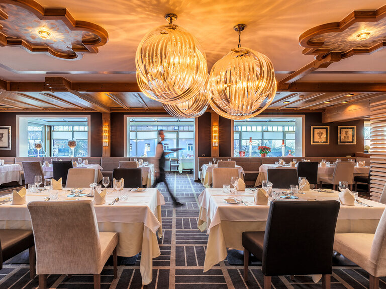 Das Restaurant Platzl im Hotel Oswald besticht durch elegantes Design mit modernen Lichtelementen und traditionellen Holzdetails.