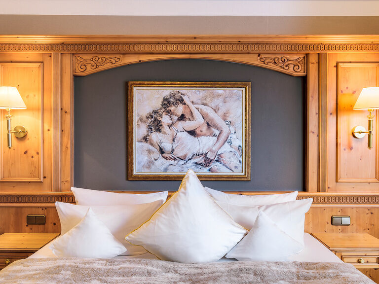 Das liebevoll gestaltete Betthaupt in der Romantiksuite des Wellnesshotels Oswald mit einem romantischen Wandgemälde.