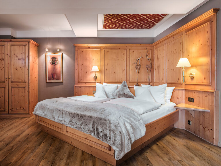 Großzügiges Doppelbett mit kuscheliger Tagesdecke in der Romantiksuite Plus im Hotel Oswald Bayerischer Wald.