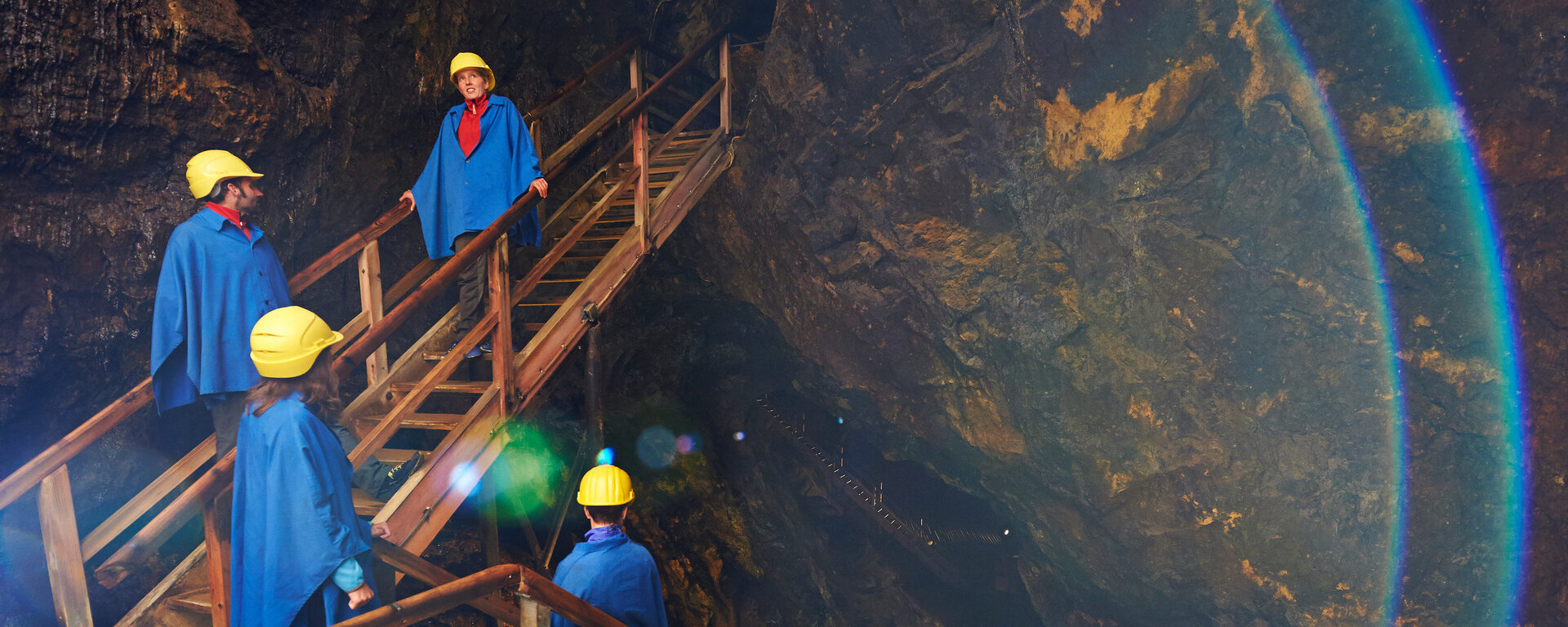 Eine Gruppe in Arbeitskleidung steht vor einem Tunnel im Bergwerk Silberberg.