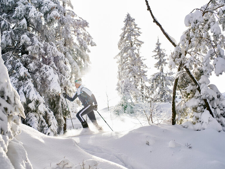 Mann wandert auf Schneewschuhen durch den tief verschneiten Bayerischen Wald.