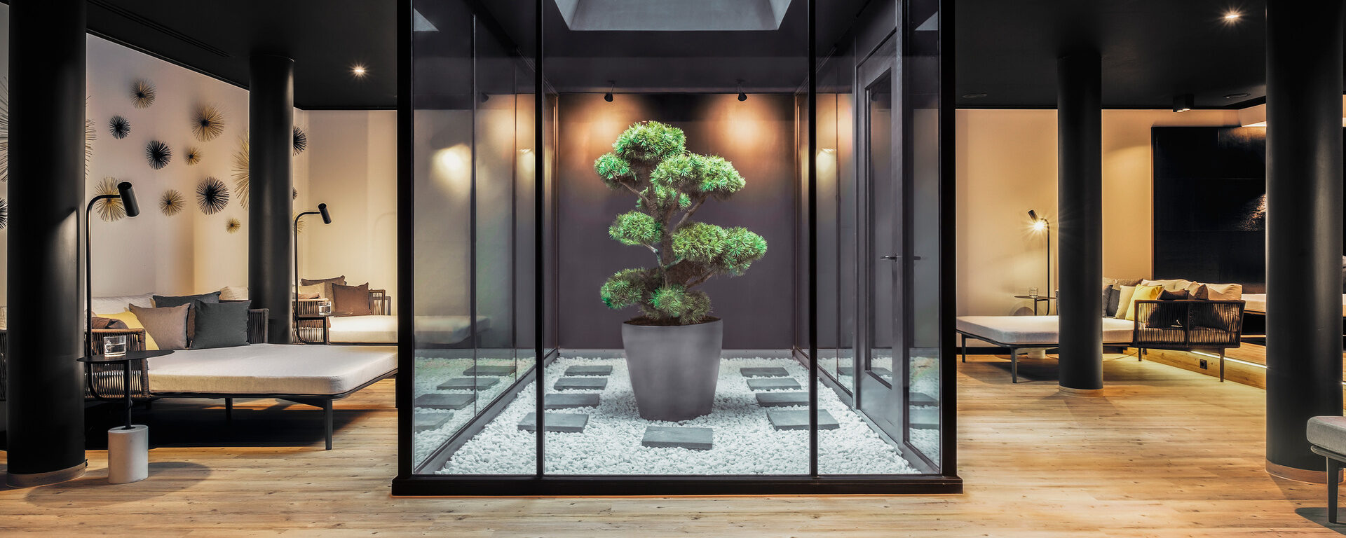 Das SPA Atrium ist ein Ruhebereich mit Zen-Garten, stilvollen Liegen und entspannender Atmosphäre im Hotel Oswald.