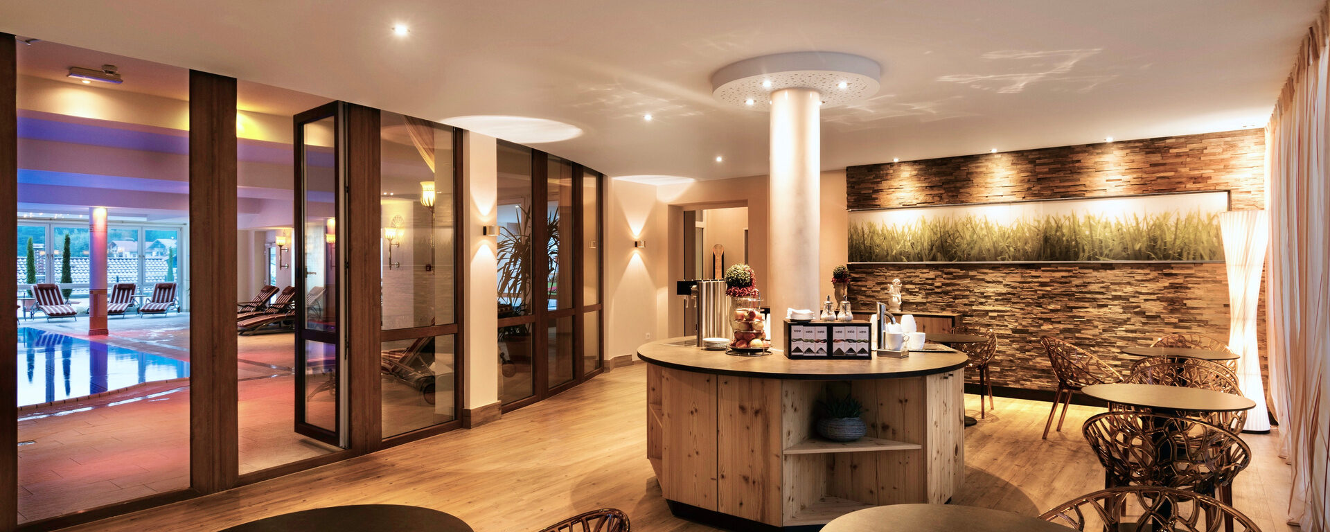 Holz- und Steinelemente, gemütliche Sitzmöglichkeiten und eine Teebar laden zu einer entspannten Pause im Wellnessbereich Hotel Oswald ein.