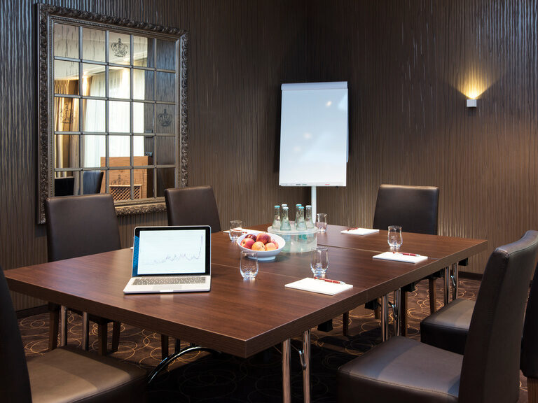 Kleinerer Abschnitt als Konferenzraum in der Event-Lounge mit edlem Holztisch und moderner Ausstattung im Hotel Oswald.