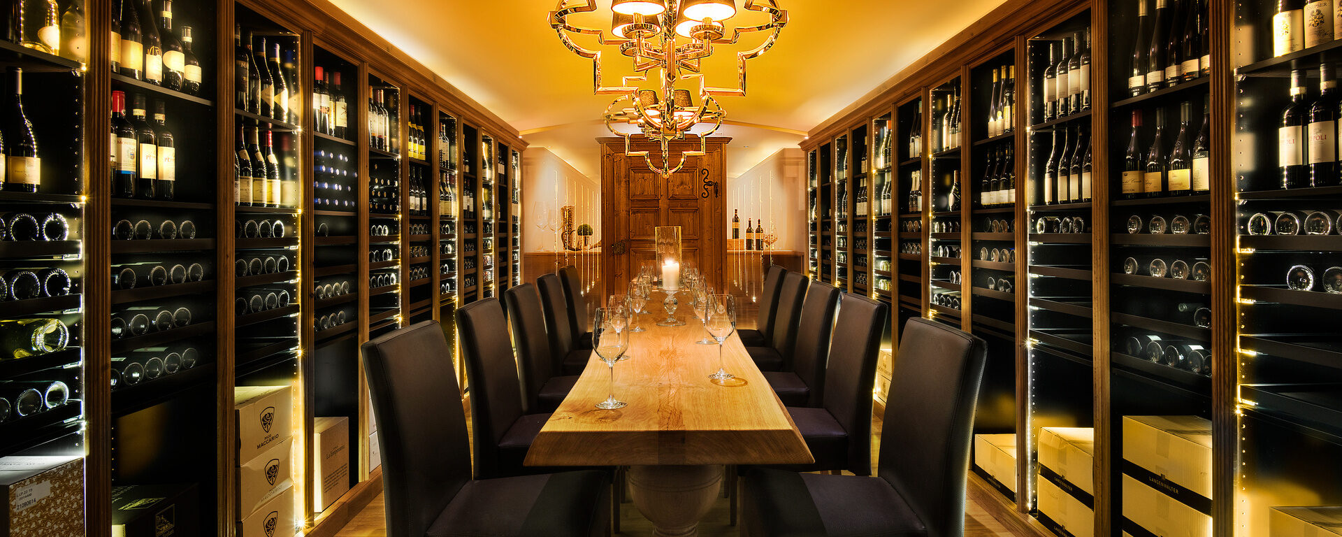 der exklusive Weinkeller im Hotel Oswald mit edler Beleuchtung, hochwertigen Weinen und stilvollem Degustationstisch für besondere Genussmomente im Bayerischen Wald.