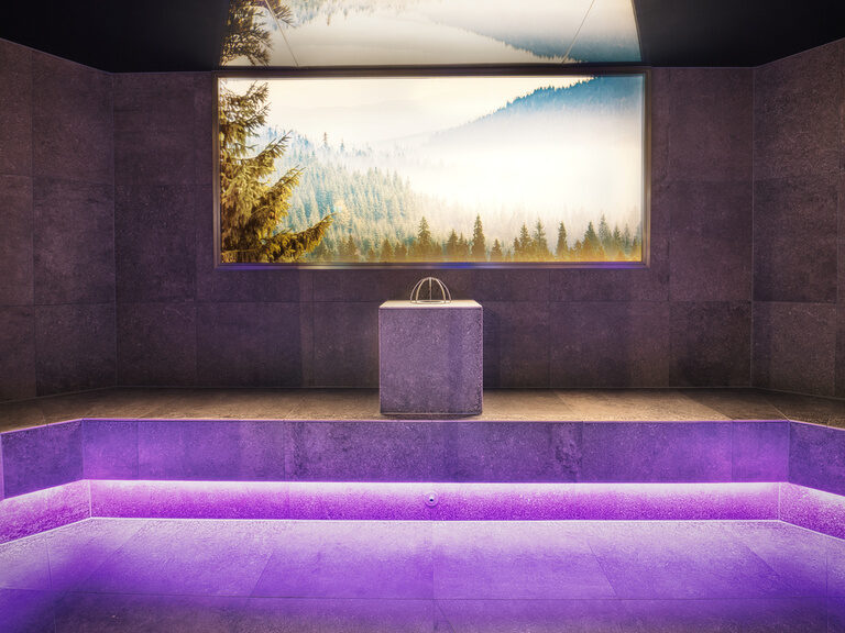 Ein lila beleuchteter Raum im Wellnessbereich eines Resorts.