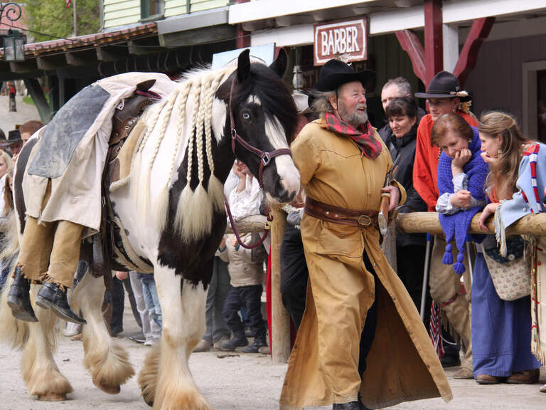 Schauspieler im Westernkostüm mit Pferd in Pullman City im Bayerischen Wald.